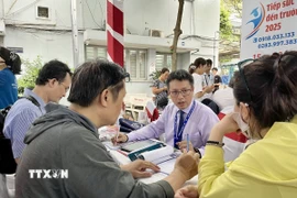 Các chuyên gia trao đổi, giải đáp thắc mắc về tuyển sinh, chọn ngành cho phụ huynh và học sinh. (Ảnh: Thu Hoài/TTXVN)