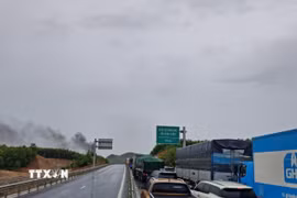 Hàng loạt phương tiện nối đuôi nhau chờ lưu thông đoạn qua khu vực cháy xe ôtô tải trên tuyến cao tốc Vạn Ninh-Cam Lộ. (Ảnh: TTXVN phát)