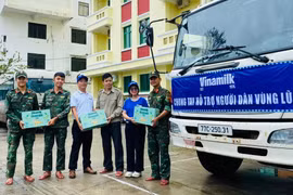 Anh Nguyễn Xuân Bình – Giám đốc Nhà máy Sữa Vinamilk Bình Định cùng cán bộ công nhân viên công ty trao tặng sản phẩm dinh dưỡng Vinamilk. (Ảnh: Vi Nam)