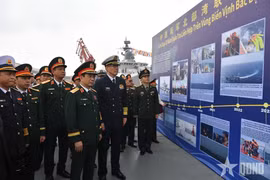 Hai Bộ trưởng tham quan khu trưng bày hình ảnh về các chuyến tuần tra liên hợp trước đây giữa hải quân hai nước. (Ảnh: Báo Quân đội Nhân dân)