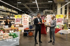 Đại sứ Vũ Quang Minh (bên phải) cảm ơn Giám đốc điều hành Selgros Lichtenberg Marco Berger đã tạo điều kiện để sản phẩm nông sản Việt Nam đến gần hơn với khách hàng Đức. (Ảnh: Phương Hoa/TTXVN)