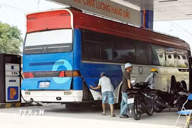 Một số xe tải cất các can dầu, chứa hàng chục lít, vào gầm xe trước khi làm thủ tục qua biên giới tại khu vực Cửa khẩu Quốc tế Lao Bảo (Quảng Trị). (Ảnh: Tá Chuyên/TTXVN)