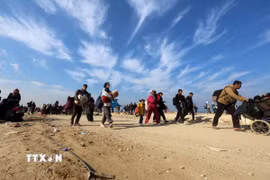 Người dân đi sơ tán tránh xung đột trở về nhà ở Gaza. (Ảnh: THX/TTXVN)