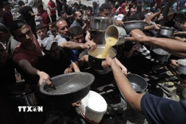 Người dân Palestine nhận thức ăn cứu trợ tại trại tị nạn Jabalia, miền Bắc Dải Gaza ngày 19/5. (Ảnh: THX/TTXVN)
