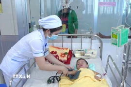 Bác sỹ Bệnh viện sản nhi An Giang điều trị cho trẻ mắc bệnh sốt xuất huyết. (Ảnh: Thanh Sang/TTXVN)