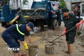 Đoàn công tác Công an tỉnh Quảng Trị có mặt tại thành phố Huế và khẩn trương tiến hành dọn vệ sinh môi trường, đẩy bùn đất tại các cơ quan, đơn vị. (Ảnh: TTXVN phát)