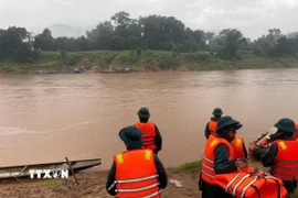 Các lực lượng chức năng triển khai công tác tìm kiếm thi thể chị H.T.H. (Ảnh: TTXVN phát)