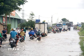 Quốc lộ 28 đoạn qua địa bàn phường Hàm Thắng (Lâm Đồng) bị ngập sâu, các phương tiện di chuyển khó khăn. (Ảnh: Nguyễn Thanh/TTXVN)