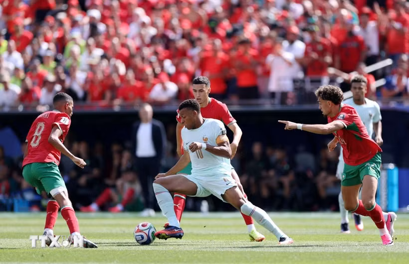 Mbappe giữa vòng vây của các cầu thủ Maroc. (Ảnh: AFP/TTXVN)