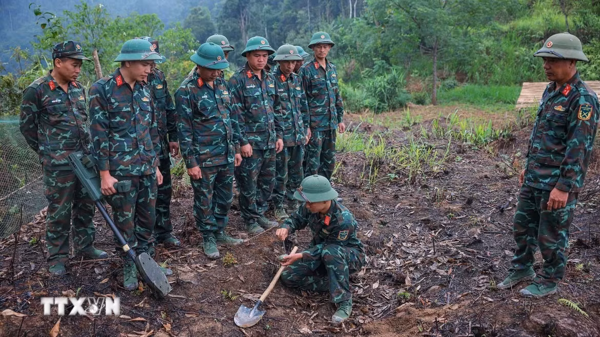 Các thành viên Đội tìm kiếm, quy tập hài cốt Liệt sĩ sử dụng máy dò mìn để đảm bảo khu vực tìm kiếm "sạch" trước khi tiến hành tìm kiếm. Ảnh: Hoàng Hiếu - TTXVN