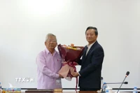 Đại sứ Việt Nam tại Lào Nguyễn Minh Tâm tặng hoa chúc mừng Nghệ sỹ Quốc gia-nhạc sỹ Lào Douangmixay Likaya. (Ảnh: Xuân Tú/TTXVN)