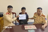 Đối tượng mua bán trái phép ma túy Cháng A Sùng cùng tang vật tại cơ quan Công an. (Ảnh: TTXVN phát)