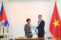 Đại sứ Nguyễn Minh Vũ trao tặng quà Tết cho bà Hà Thị E, có công trong cuộc kháng chiến chống Mỹ cứu nước, được Thủ tướng Chính phủ Việt Nam cấp bằng khen năm 2009. (Ảnh: Huỳnh Thảo/TTXVN)