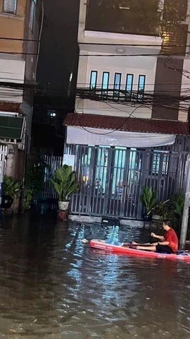 Người dân phải dùng thuyền để di chuyển tại khu vực ngã ba cống trên đường Thích Quảng Đức, thành phố Thủ Dầu Một, tỉnh Bình Dương. (Ảnh: TTXVN phát)