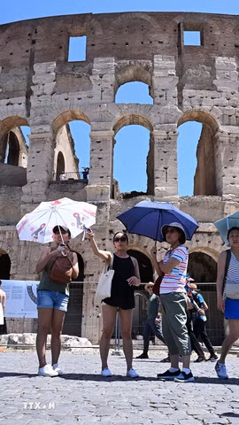 Khách du lịch tham quan tại điểm du lịch nổi tiếng Đấu trường La Mã Colosseum của Italy. (Ảnh: TTXVN)
