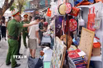 Tổ công tác của Công an phường Hoàn Kiếm xử lý vi phạm về trật tự đô thị tại phố Trần Phú. (Ảnh: Phạm Kiên/TTXVN)