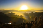 Ánh nắng mặt trời xuyên qua những áng mây bồng bềnh giữa núi đồi. (Ảnh: Xuân Tư/TTXVN)
