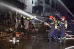 Lực lượng chức năng phun nước làm mát ngăn ngọn lửa bùng phát trở lại. (Ảnh: Lê Xuân/TTXVN)