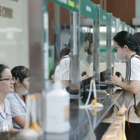 Người dân đến khám bệnh đăng ký tại quầy tiếp đón. (Ảnh: Minh Quyết/TTXVN)