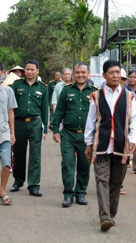 Già làng, người có uy tín trong cộng đồng và lực lượng biên phòng “đi từng ngõ, gõ từng nhà” để hướng dẫn người dân quy trình bỏ phiếu bầu cử đúng theo quy định. (Ảnh: Hồng Điệp/TTXVN)