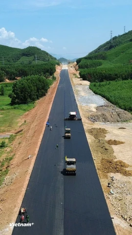 Nhà thầu thi công thảm bêtông nhựa nền đường Dự án cao tốc Quy Nhơn-Chí Thạnh. (Ảnh: Khánh Hùng/Vietnam+)