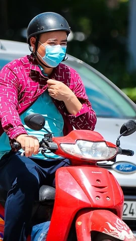 Người dân di chuyển dưới trời nắng gắt. (Ảnh: Hoài Nam/Vietnam+)
