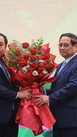 Thủ tướng Phạm Minh Chính tặng hoa chúc mừng quyền Bộ trưởng Bộ Nông nghiệp và Môi trường Trần Đức Thắng. (Ảnh: Hoàng Hiếu/TTXVN)