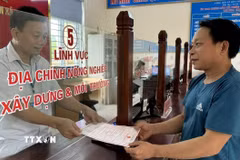 Người dân làm thủ tục hành chính tại bộ phận một cửa xã Phúc Thịnh, huyện Ngọc Lặc phấn khởi nhận kết quả. (Ảnh: TTXVN phát)