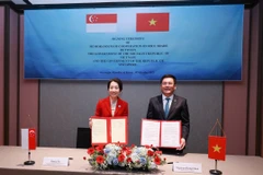 Bộ trưởng Bộ Công thương Việt Nam Nguyễn Hồng Diên (phải) và Bộ trưởng Phát triển bền vững và môi trường kiêm Bộ trưởng phụ trách Quan hệ Thương mại Singapore Grace Fu trao đổi Bản ghi nhớ. (Ảnh: BCT/Vietnam+)