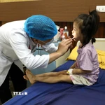 Bác sỹ thăm khám cho trẻ em mắc bệnh hô hấp. (Ảnh: TTXVN/Vietnam+)