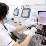 Chuyển đổi số được đẩy mạnh trong ngành y tế. Kỹ thuật viên xét nghiệm quét mã và nhập dữ liệu mẫu máu vào hệ thống, bảo đảm quản lý chính xác. (Ảnh: TTXVN)