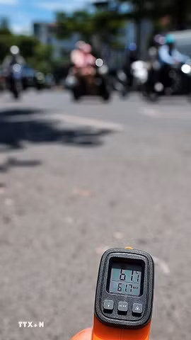 Thiết bị đo nhiệt cho thấy nhiệt độ bề mặt mặt đường ngoài trời lên tới hơn 61 độ C vào thời điểm giữa trưa ngày 25/5. (Ảnh: Phạm Tuấn Anh/TTXVN)