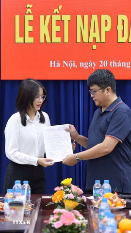 Bí thư Chi bộ Ngữ văn 3 trao quyết định kết nạp cho đảng viên mới. (Ảnh: Thanh Tùng/TTXVN)