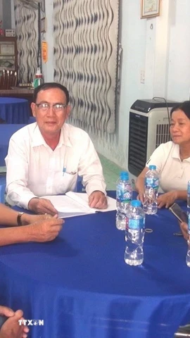 Ông Nguyễn Hoài Trung, Bí thư Chi bộ, Trưởng khu phố 3, xã Đức Hòa, tỉnh Tây Ninh đang trao đổi cùng tổ an ninh tự quản. (Ảnh: Thanh Bình/TTXVN)
