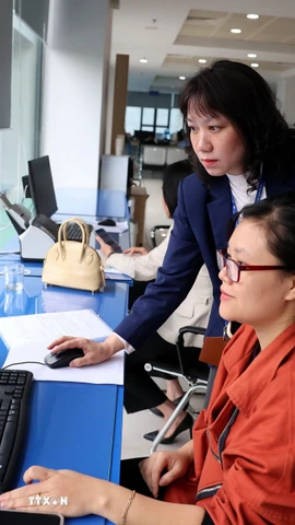 Cán bộ Trung tâm Phục vụ hành chính công thành phố Hà Nội thực hiện giải quyết thủ tục hành chính cho người dân. (Ảnh: Vũ Quang/TTXVN)