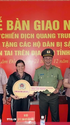 Đại tá Nay Gia Phú, Phó Giám đốc Công an tỉnh Lâm Đồng trao căn nhà mới hoàn thành cho gia đình chị Nguyễn Thị Hương Lan. (Ảnh TTXVN phát)