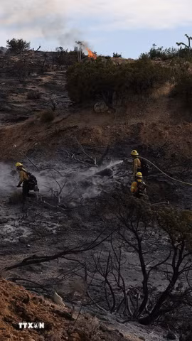 Lực lượng cứu hỏa dọn dẹp tàn dư sau khi khống chế một đám cháy ở Mỹ. (Ảnh: THX/TTXVN phát)