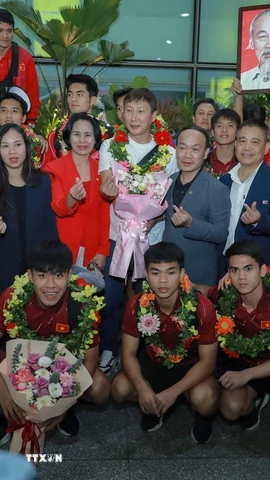 Lãnh đạo Cục Thể dục thể thao và người hâm mộ chụp ảnh lưu niệm cùng đội tuyển Việt Nam. (Ảnh: Phan Phương/TTXVN)