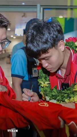 Cầu thủ đội tuyển bóng đá Việt Nam ký tặng người hâm mộ. (Ảnh: Phan Phương/TTXVN)