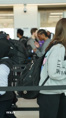 Hành khách xếp hàng qua cửa an ninh tại sân bay LaGuardia ở New York, Mỹ. (Nguồn: THX/TTXVN)
