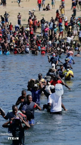 Người di cư vượt sông Rio Bravo ở biên giới Mỹ-Mexico. (Ảnh: THX/TTXVN)