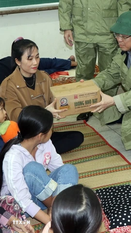 Chủ tịch Ủy ban Nhân dân tỉnh Quảng Ngãi Nguyễn Hoàng Giang thăm, tặng quà ở điểm tập kết người dân tránh bão số 13 tại Trường Tiểu học, Trung học cơ sở Đức Lợi. (Ảnh: Cao Nguyên/TTXVN)