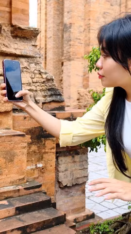 Du khách quét QR tìm hiểu thông tin tại Di tích Quốc gia Đặc biệt Tháp Bà Pô Nagar (phường Bắc Nha Trang, Khánh Hòa). (Ảnh: Nguyễn Thành/TTXVN)