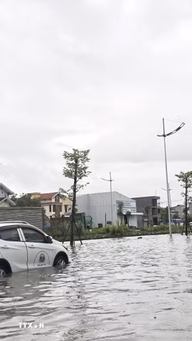Có người phải đẩy xe ôtô do chết máy giữa đường vì ngập nước. (Ảnh: Thanh Vân/TTXVN)