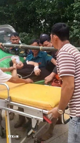 Sản phụ được khiêng từ vùng cô lập đến cơ sở y tế. (Ảnh: TTXVN phát)