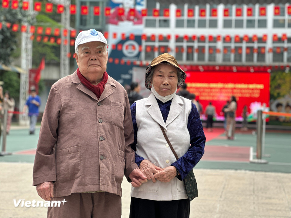 Cụ ông Nguyễn Văn Rừng (95 tuổi) và cụ bà Lê Thị Khiên (83 tuổi) phấn khởi cùng nắm tay nhau đi bộ tới điểm bầu cử. (Ảnh: Thùy Giang/Vietnam+)