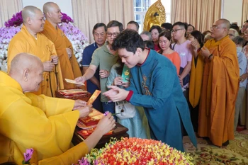 Trưởng lão Hòa thượng Thích Thiện Nhơn – Phó Pháp chủ Hội đồng Chứng minh, Chủ tịch Hội đồng Trị sự Giáo hội Phật giáo Việt Nam lì xì năm mới cho các phật tử đến Chùa Minh Đạo. (Ảnh: Khánh Ly/Vietnam+)