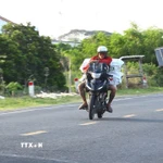 Đối tượng điều khiển xe môtô với tốc độ cao để vận chuyển thuốc lá lậu trên Quốc lộ 30, đoạn qua xã An Long, tỉnh Đồng Tháp. (Ảnh: Nhựt An/TTXVN)