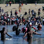 Người di cư vượt sông Rio Bravo ở biên giới Mexico để vào Mỹ. (Ảnh: THX/TTXVN)