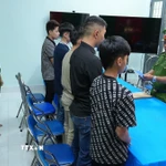 Cơ quan Cảnh sát điều tra Công an tỉnh Đồng Tháp tống đạt Quyết định khởi tố và ra Lệnh cấm đi khỏi nơi cưu trú đối với 5 bị can. (Ảnh: TTXVN phát)
